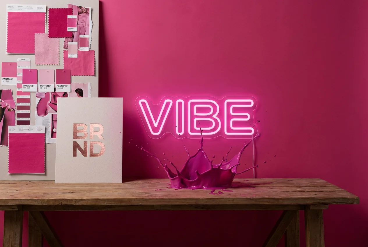 Hot pink branding studio with neon Vibe sign and paint splash